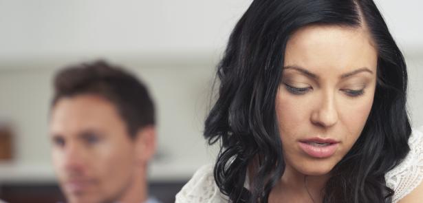 upset woman with man blurred in background