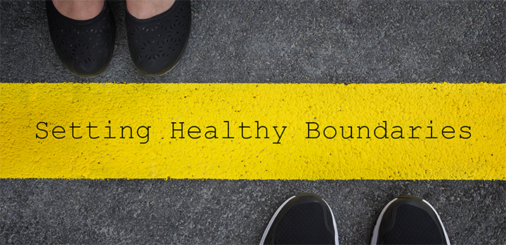 words "setting healthy boundaries" on a yellow boundary lines and shoes on either side of it